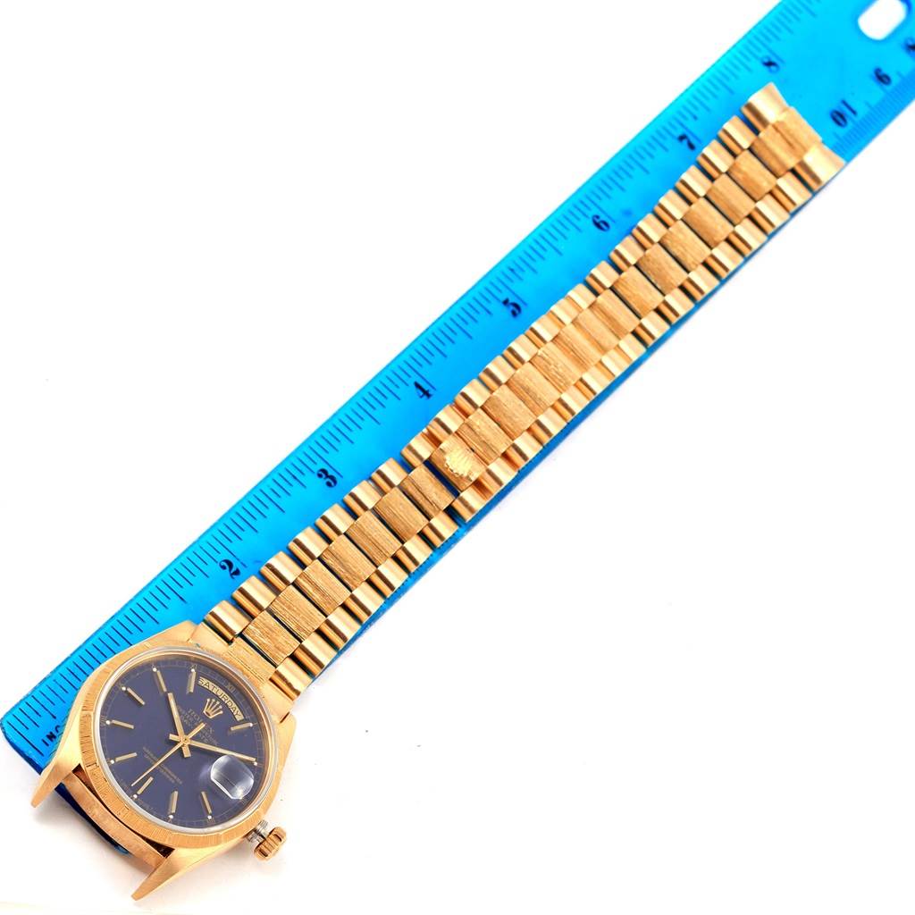 The image shows a Rolex President 18078 Men's Yellow Gold Blue Dial 18078 Men's Yellow Gold Blue Dial model watch laid flat next to a blue ruler, displaying the face and band.