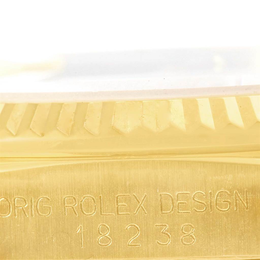 This close-up image shows the side of a Rolex President 18238 Men
s Yellow Gold Silver Dial 18238 Men
s Yellow Gold Silver Dial watch case, highlighting the model number and part of the fluted bezel.