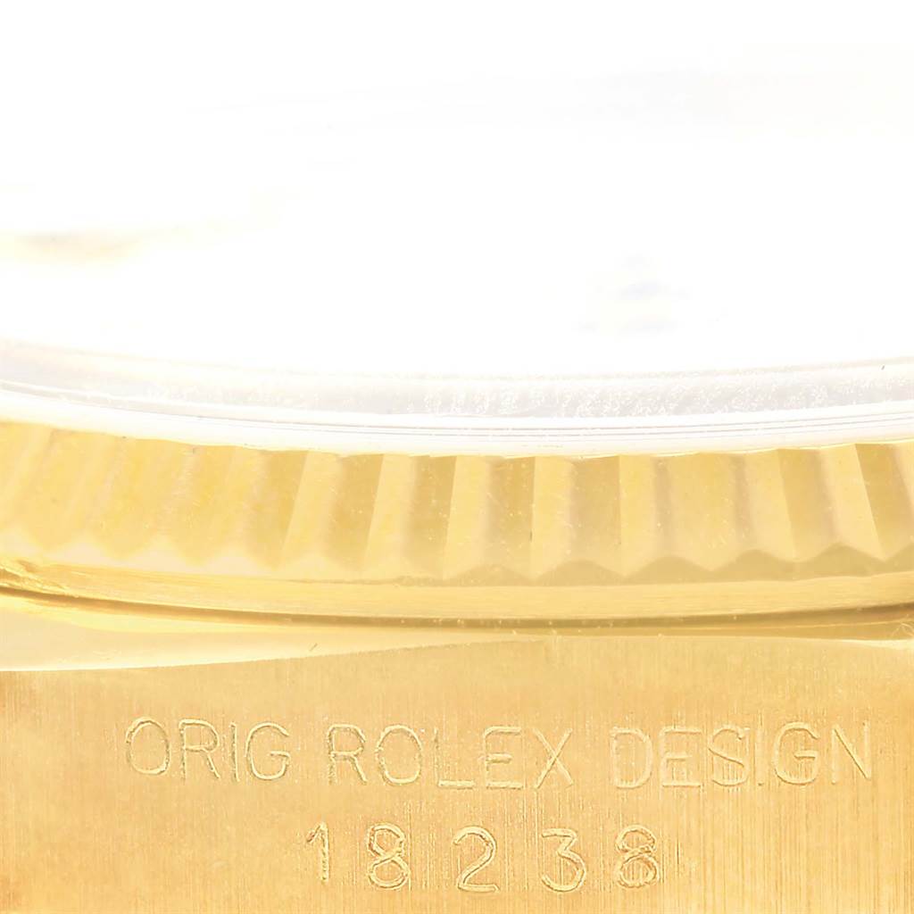 The image shows a close-up of the side of a Rolex President 18238 Men's Yellow Gold White Dial 18238 Men's Yellow Gold White Dial model watch, highlighting the fluted bezel and the "ORIG ROLEX DESIGN" engraving.