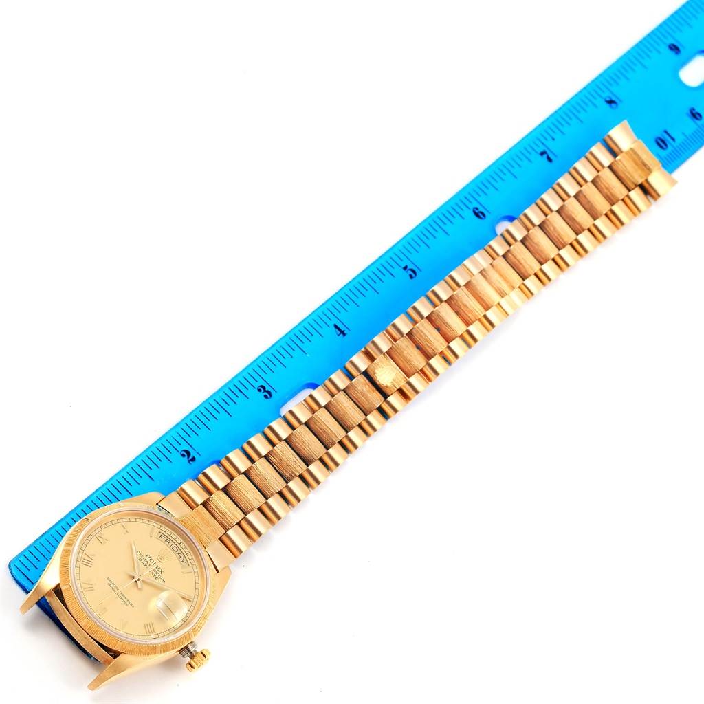 The Rolex President 18078 Men's Yellow Gold Champagne Dial 18078 Men's Yellow Gold Champagne Dial model watch is shown from a top-down angle, highlighting the face, case, band, and clasp alongside a ruler.