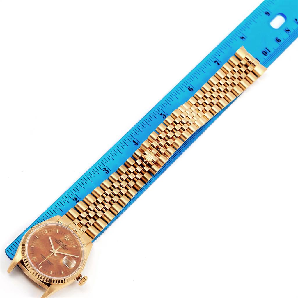 This image shows a Rolex President 16238 Men
s Yellow Gold Brown Dial 16238 Men
s Yellow Gold Brown Dial model watch in a fully extended position alongside a ruler for measurement.