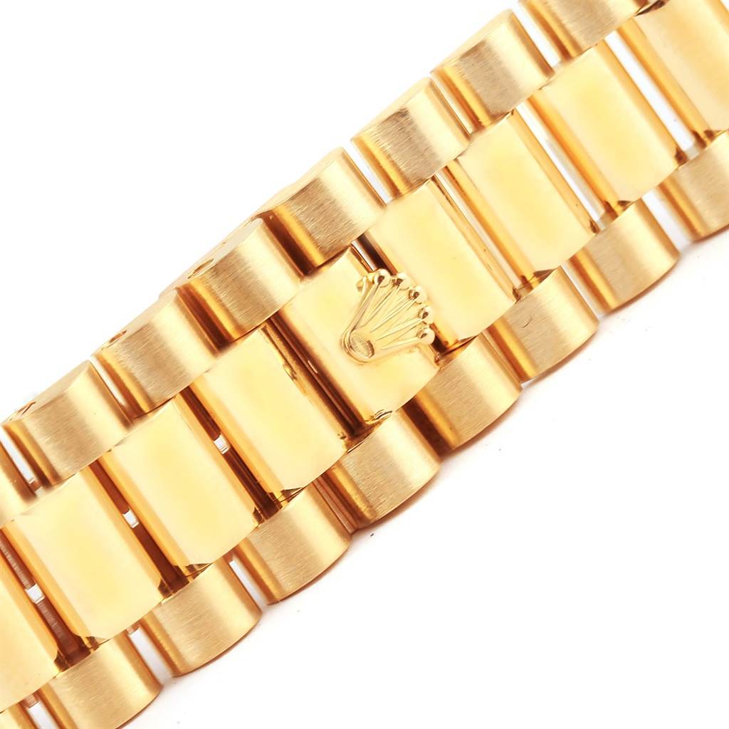 The image shows a close-up of the gold bracelet links with a Rolex crown logo on a President model by Rolex.