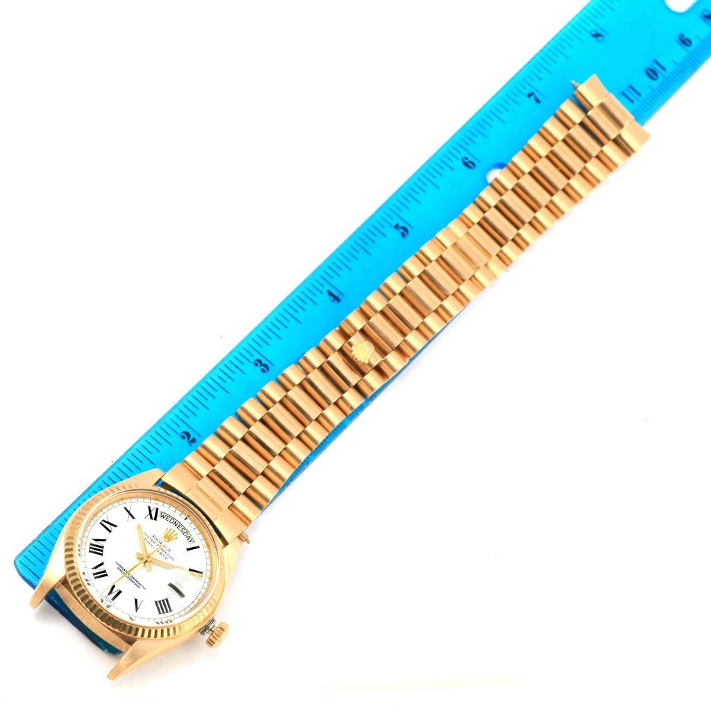 The image shows a Rolex President 1803 Men's Yellow Gold White Dial 1803 Men's Yellow Gold White Dial model watch laid flat next to a ruler, showcasing its gold bracelet and watch face.