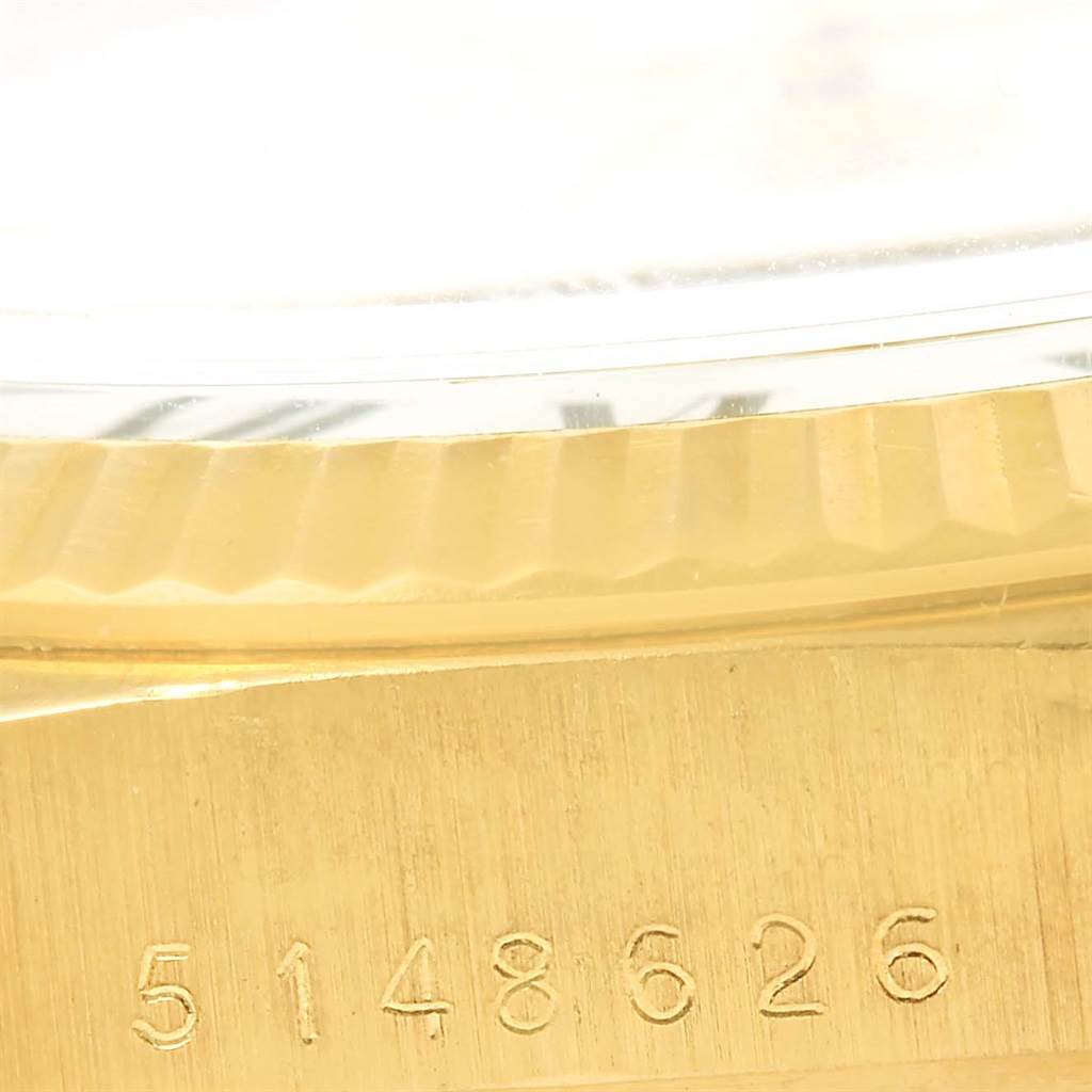 This close-up image of a President model by Rolex shows the side of the watch case and partially the fluted bezel, along with a serial number.