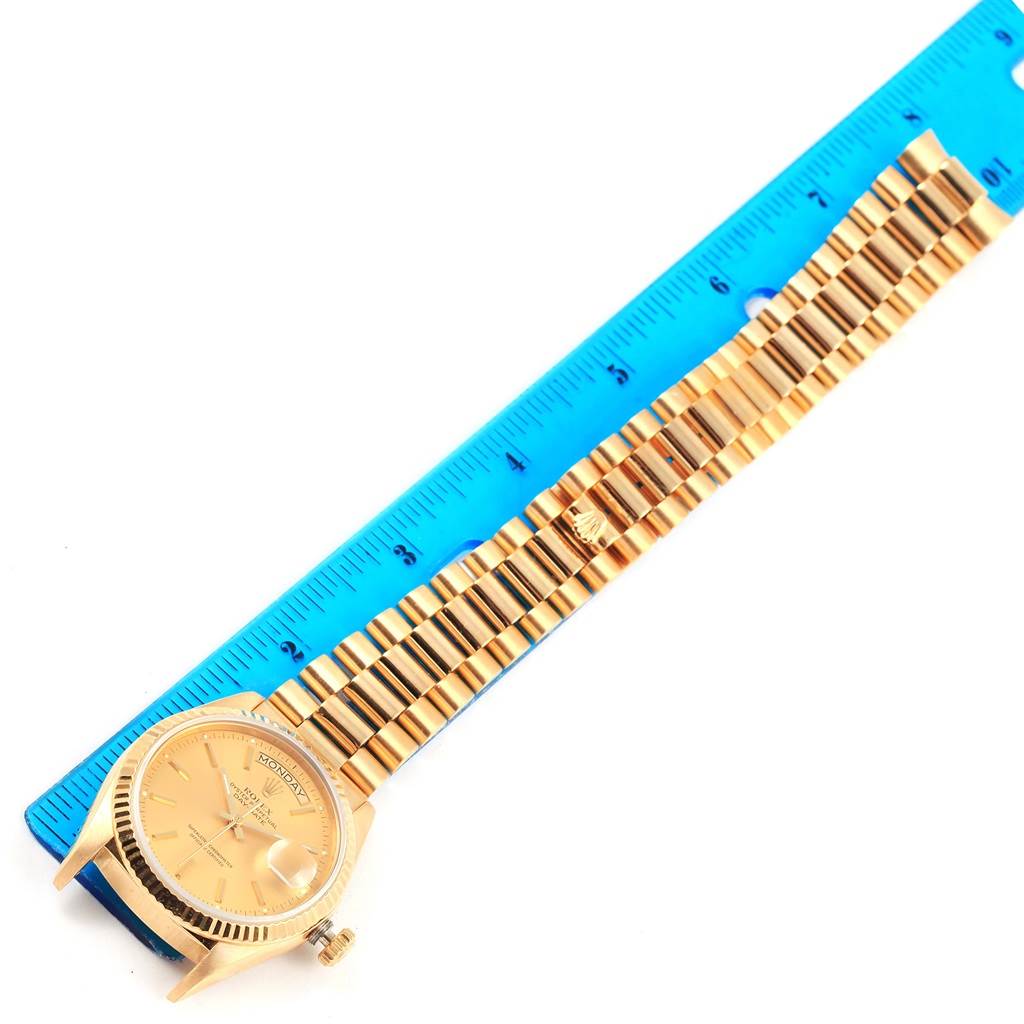 This image shows a Rolex President 18038 Men's Yellow Gold Champagne Dial 18038 Men's Yellow Gold Champagne Dial model watch laid flat next to a blue ruler for size measurement.