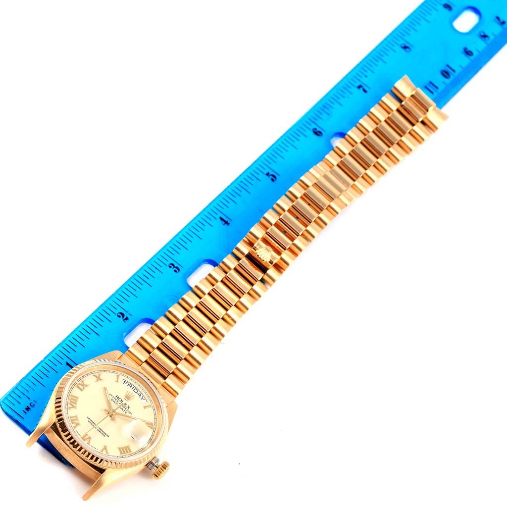 The image shows a Rolex President 18038 Men
s Yellow Gold Beige Dial 18038 Men
s Yellow Gold Beige Dial model watch laid flat next to a blue ruler, displaying the face and full bracelet from above.