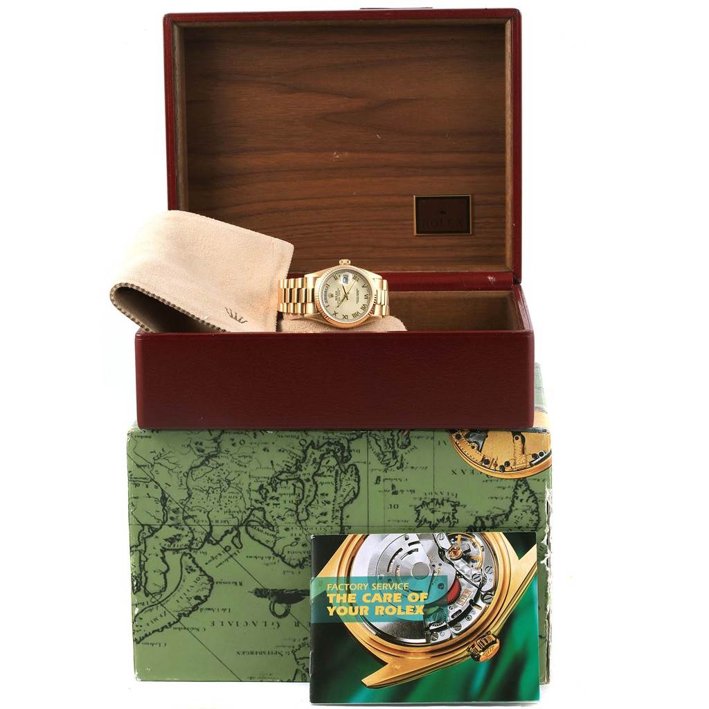 This image shows a Rolex President 18038 Men
s Yellow Gold Beige Dial 18038 Men
s Yellow Gold Beige Dial model watch in its open box with a cloth and a service manual.