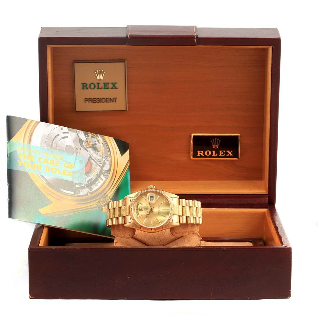 The Rolex President 18248 Men's Yellow Gold Champagne Dial 18248 Men's Yellow Gold Champagne Dial model watch is displayed head-on in an open box, accompanied by a booklet and branding plates.