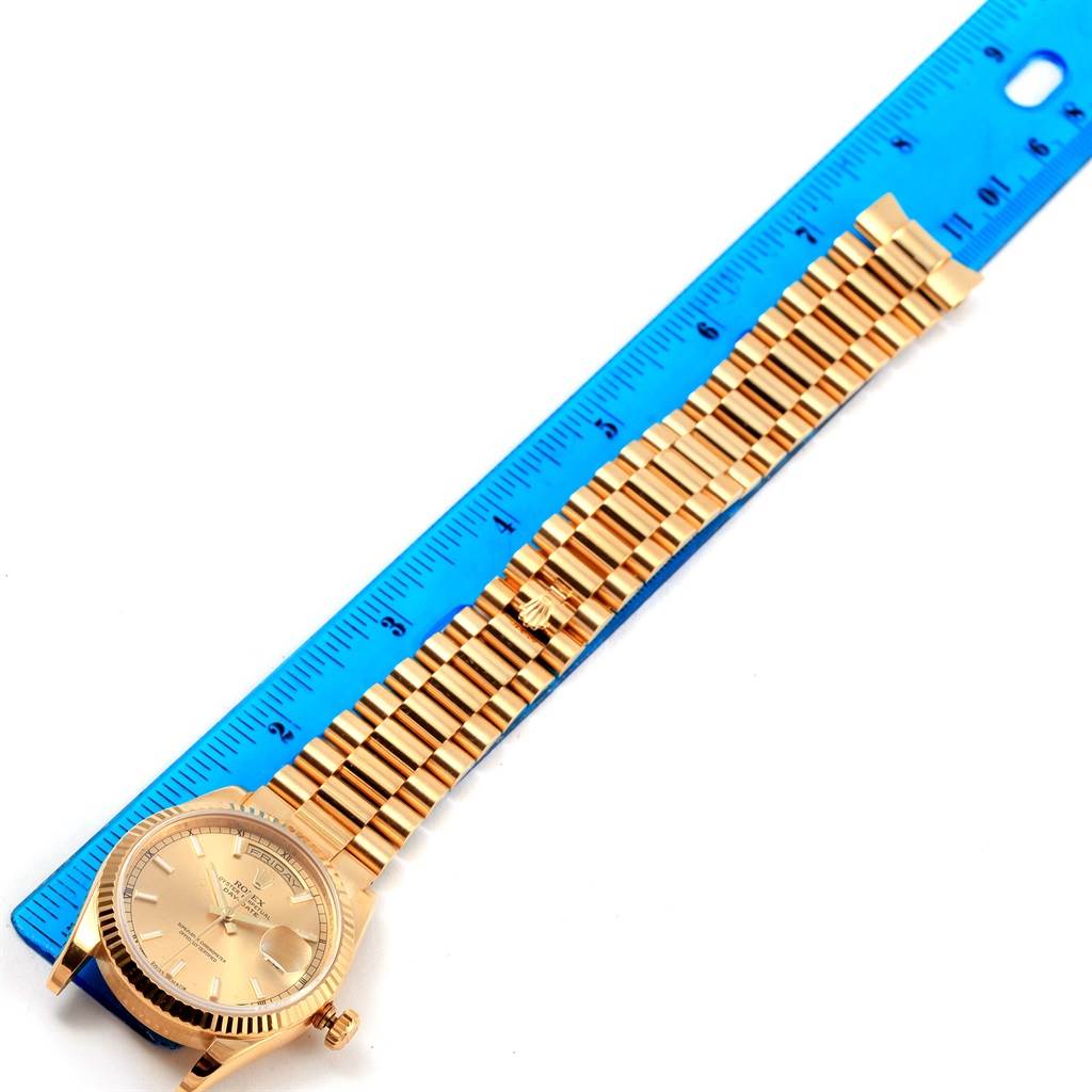The image shows a Rolex President 118238 Men's Yellow Gold Champagne Dial 118238 Men's Yellow Gold Champagne Dial model watch laid flat next to a blue ruler, highlighting its bracelet and watch face.