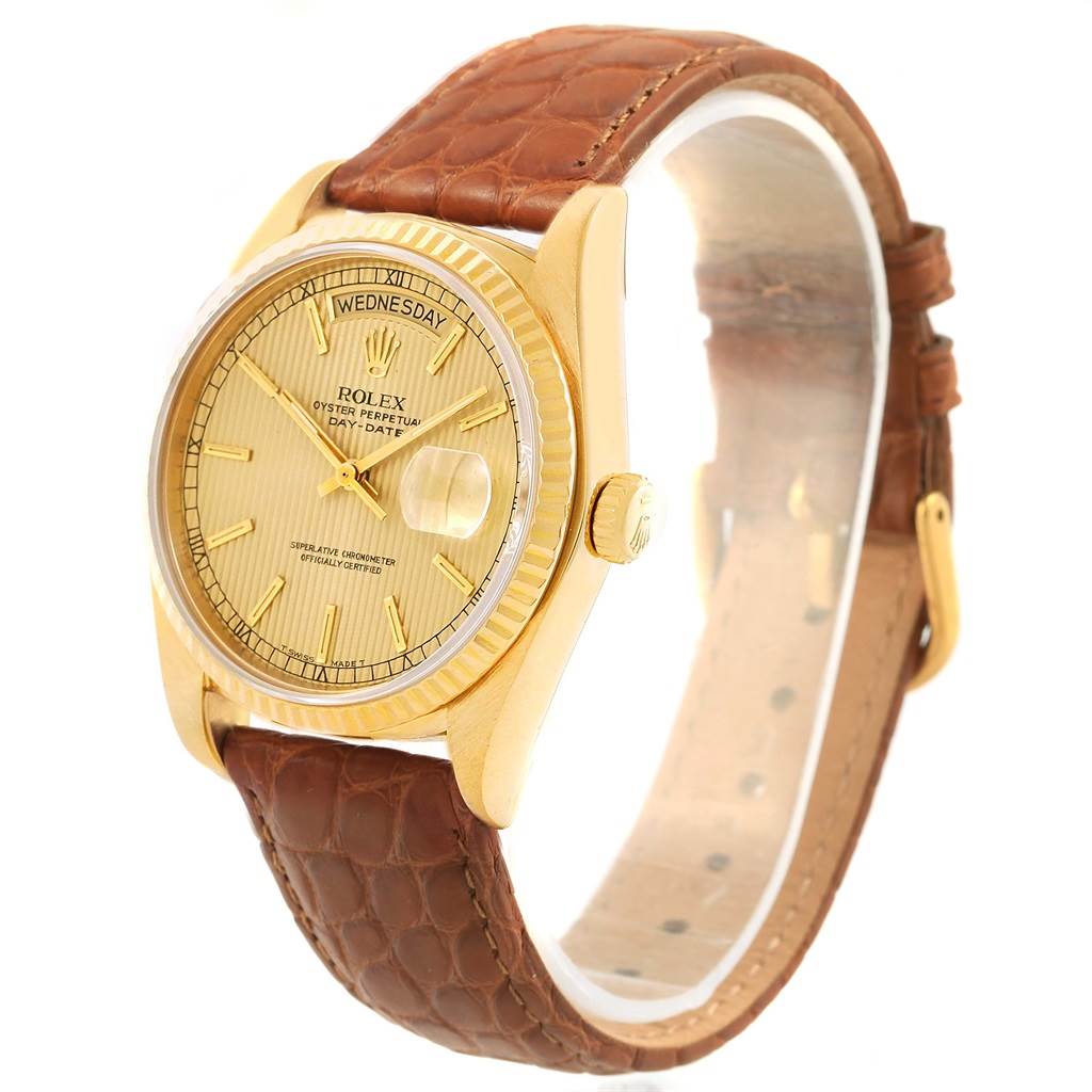 The Rolex President 18038 Men
s Yellow Gold Champagne Dial 18038 Men
s Yellow Gold Champagne Dial watch is shown at an angle displaying the face, bezel, crown, and part of its brown leather strap.