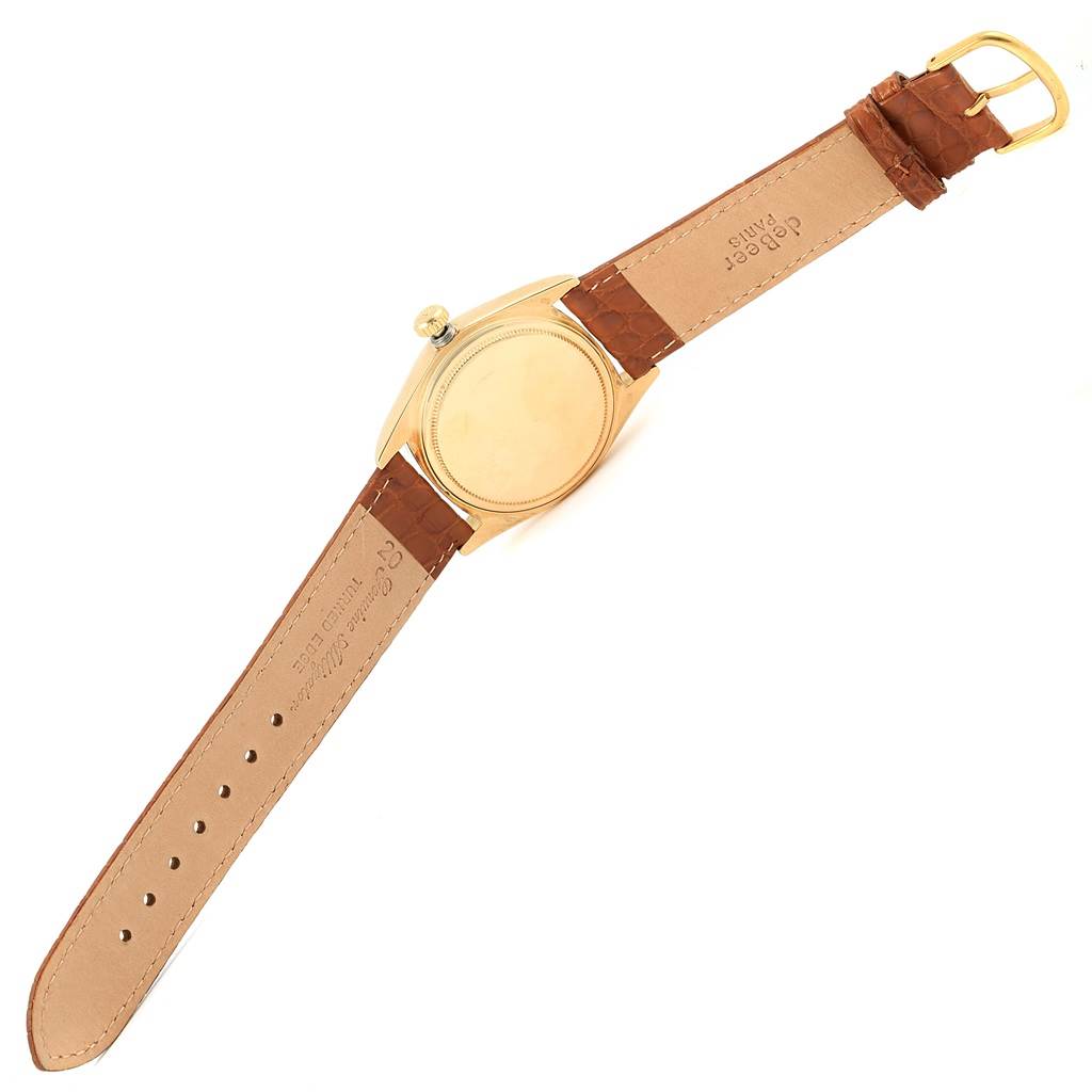 This image shows the President model Rolex watch from the back, featuring its case and brown leather strap.