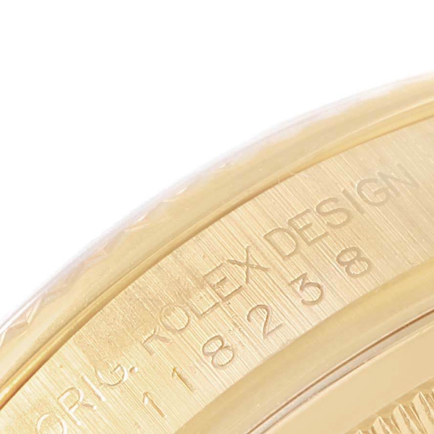 The image shows a close-up of the side of the Rolex President 118238 Men
s Yellow Gold Champagne Dial 118238 Men
s Yellow Gold Champagne Dial model, focusing on the engraved "ORIG. ROLEX DESIGN" and serial number.