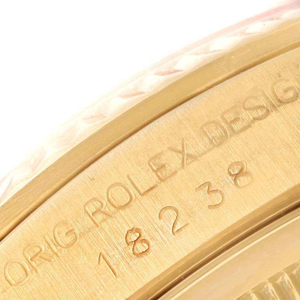 This image shows a close-up angle of the engraved bezel and serial number of a Rolex President 18238 Men's Yellow Gold Beige Dial 18238 Men's Yellow Gold Beige Dial model watch.