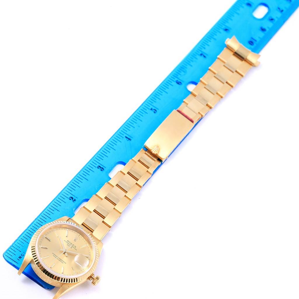 The image shows a Rolex President 15238 Men
s Yellow Gold Champagne Dial 15238 Men
s Yellow Gold Champagne Dial model watch, angled flat with the dial, bracelet, and clasp aligned next to a blue ruler.