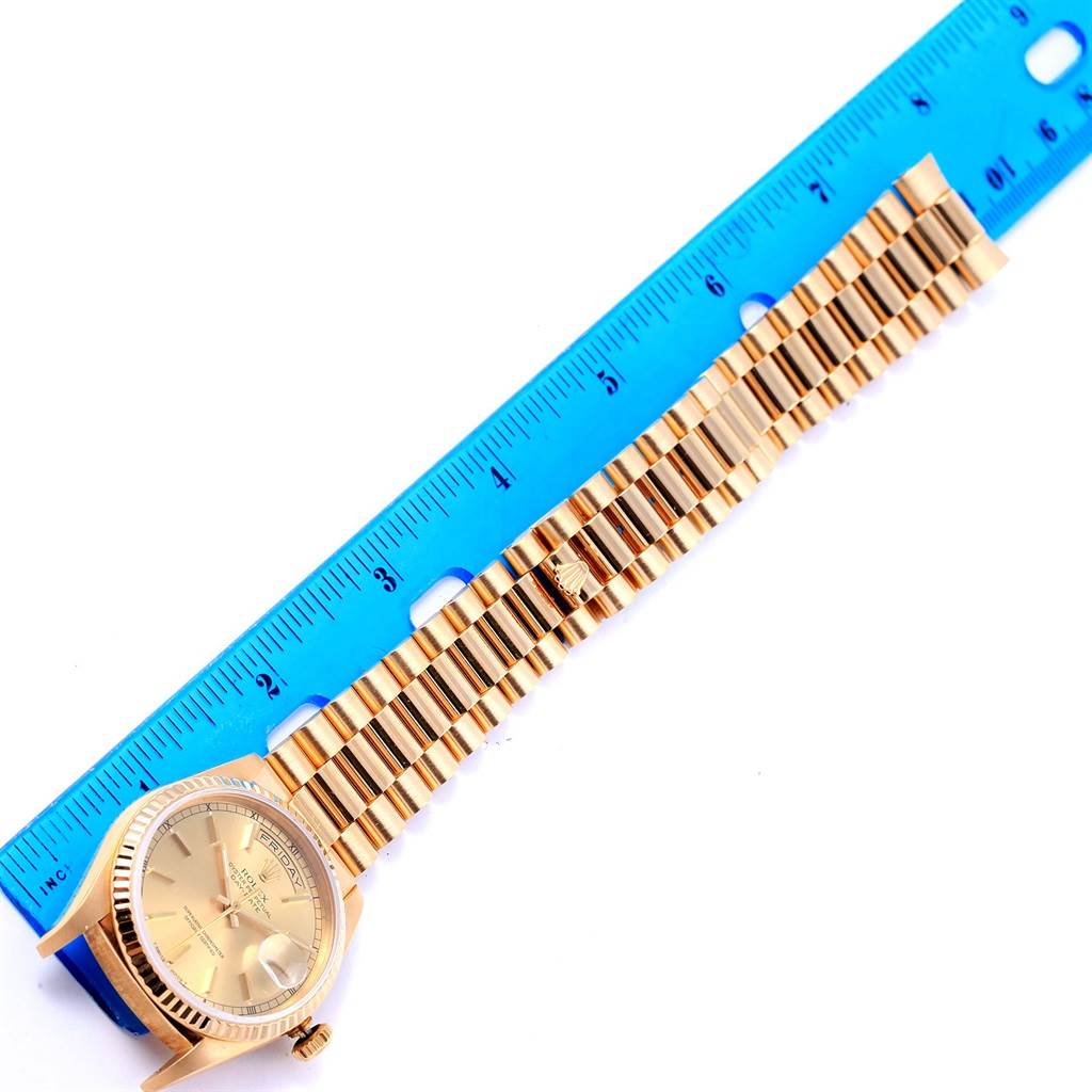 The image shows a Rolex President 18238 Men's Yellow Gold Champagne Dial 18238 Men's Yellow Gold Champagne Dial model watch with the face and entire bracelet laid flat next to a blue ruler.