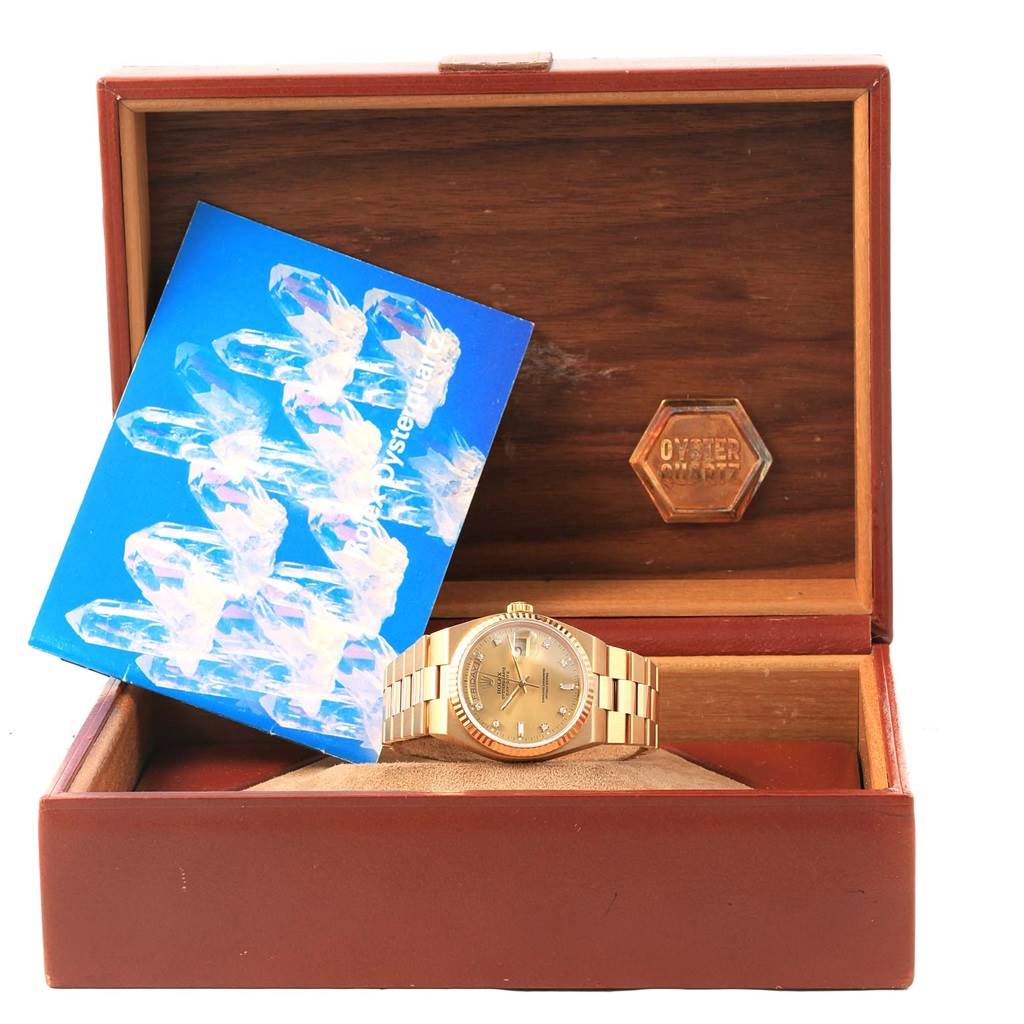 The image shows a Rolex President 19018 Men's Yellow Gold Champagne Dial 19018 Men's Yellow Gold Champagne Dial model watch in a wooden display box, along with a booklet.