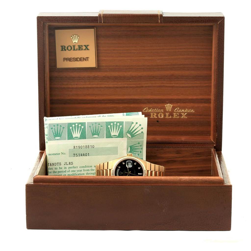 The image shows a Rolex President 19018 Men's Yellow Gold Black Dial 19018 Men's Yellow Gold Black Dial model watch in its wooden box, alongside its paperwork and documentation.