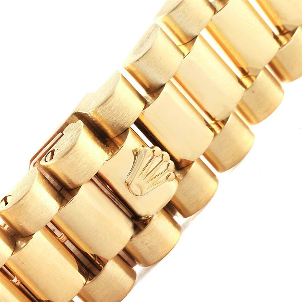 This image shows a close-up of the gold bracelet links with the Rolex logo on the President model by Rolex.