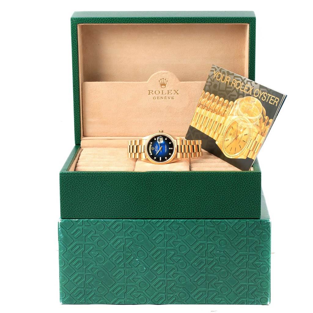 The Rolex President 18238 Men's Yellow Gold Blue Dial 18238 Men's Yellow Gold Blue Dial model watch is shown in an open green box, displaying its bracelet and dial, along with a booklet.