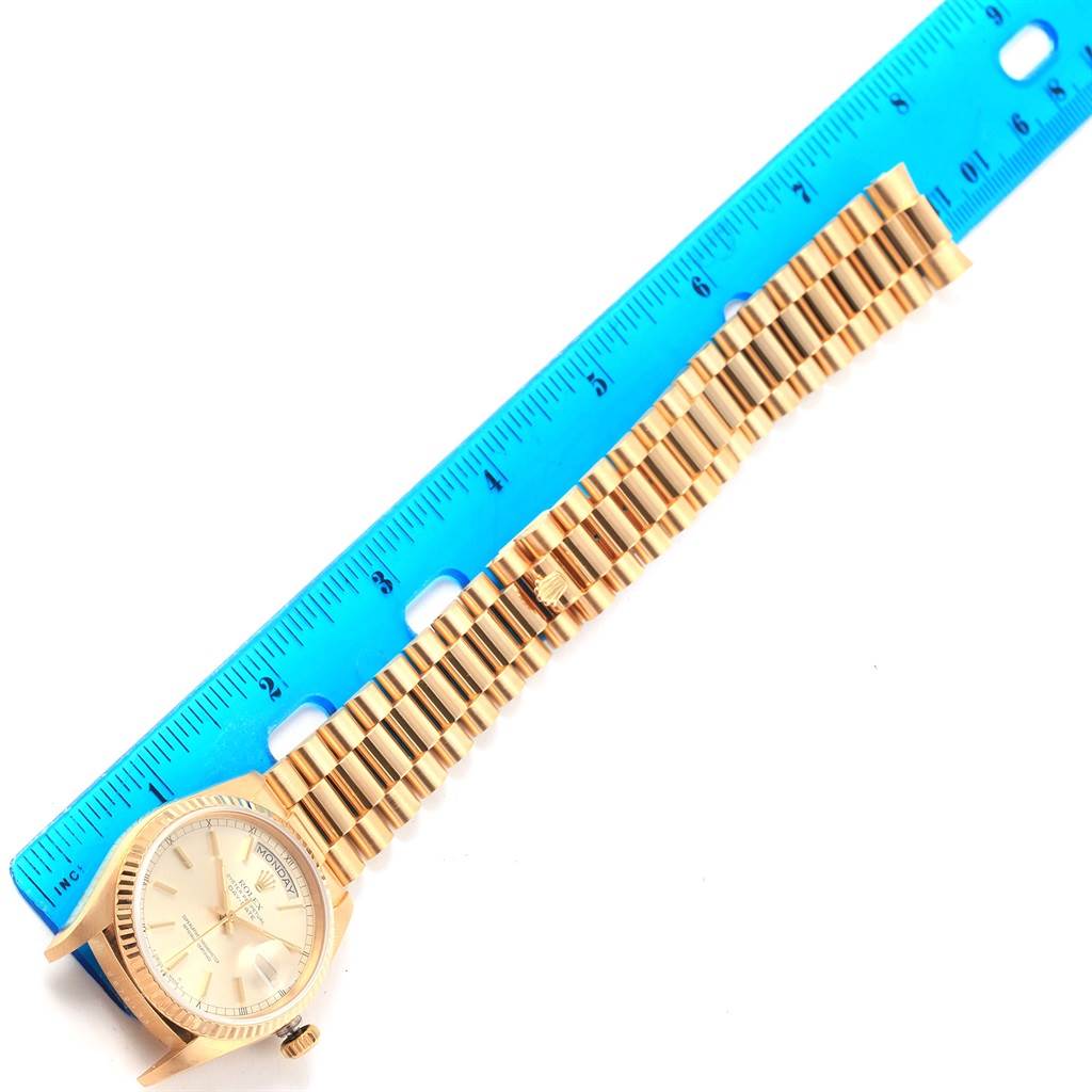 The image shows a Rolex President 18038 Men's Yellow Gold Silver Dial 18038 Men's Yellow Gold Silver Dial model watch lying flat with its face and bracelet visible alongside a blue ruler.