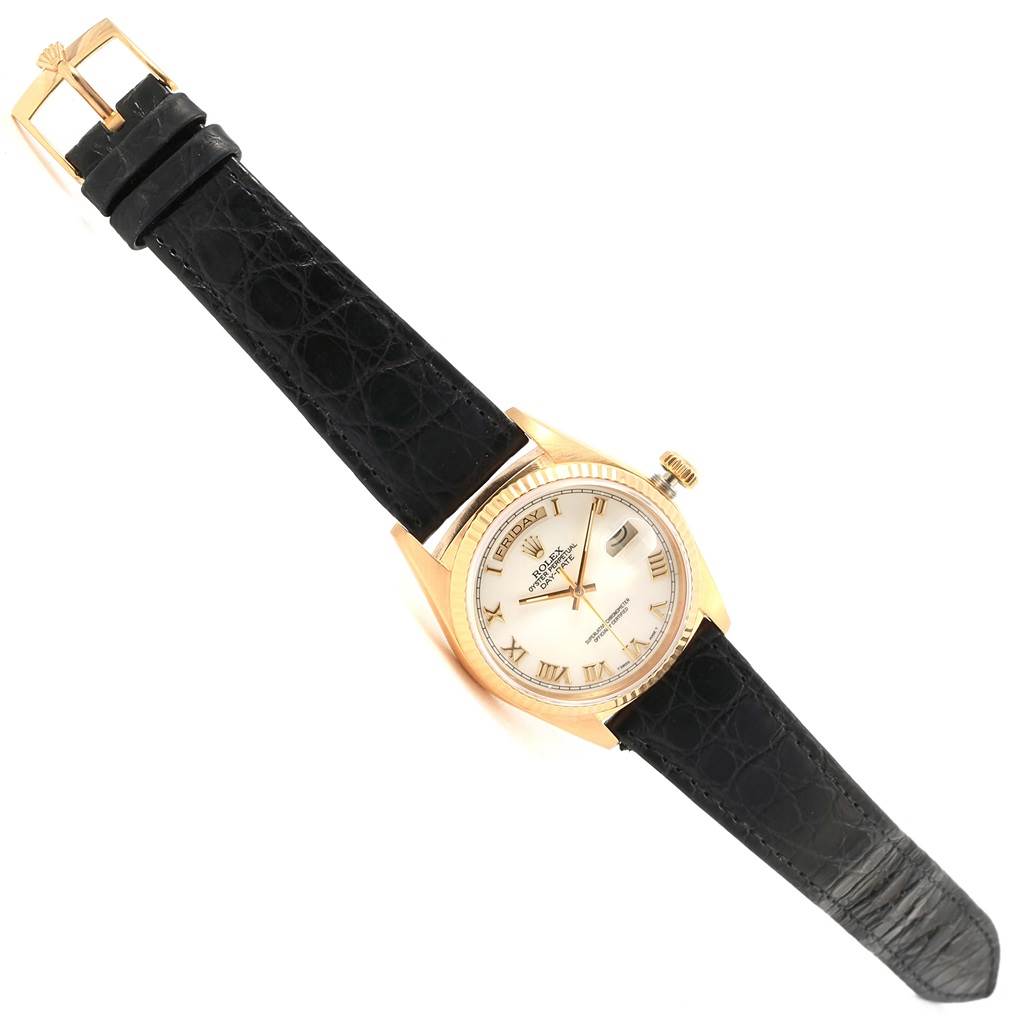 The Rolex President 18038 Men's Yellow Gold White Dial 18038 Men's Yellow Gold White Dial model watch is shown at a slightly tilted angle, displaying its face, black strap, and gold buckle.