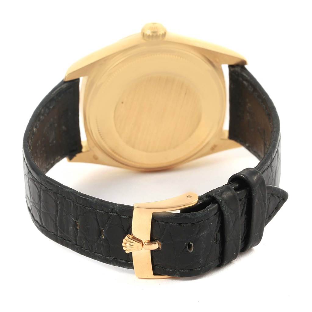 This image shows the back case and black leather strap with buckle of a Rolex President 18038 Men's Yellow Gold White Dial 18038 Men's Yellow Gold White Dial model watch.