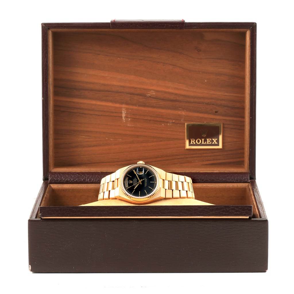 The Rolex President 19018 Men
s Yellow Gold Black Dial 19018 Men
s Yellow Gold Black Dial model watch is shown from the front, displayed inside an open brown wooden Rolex box.