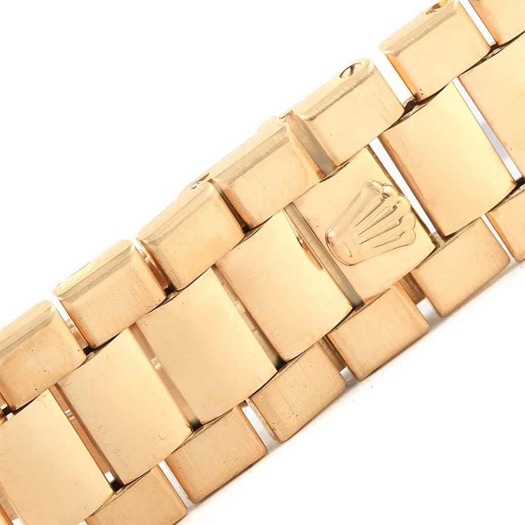 The image shows a close-up of the bracelet of a Rolex President 19018 Men
s Yellow Gold Black Dial 19018 Men
s Yellow Gold Black Dial model watch, featuring the iconic Rolex crown logo.