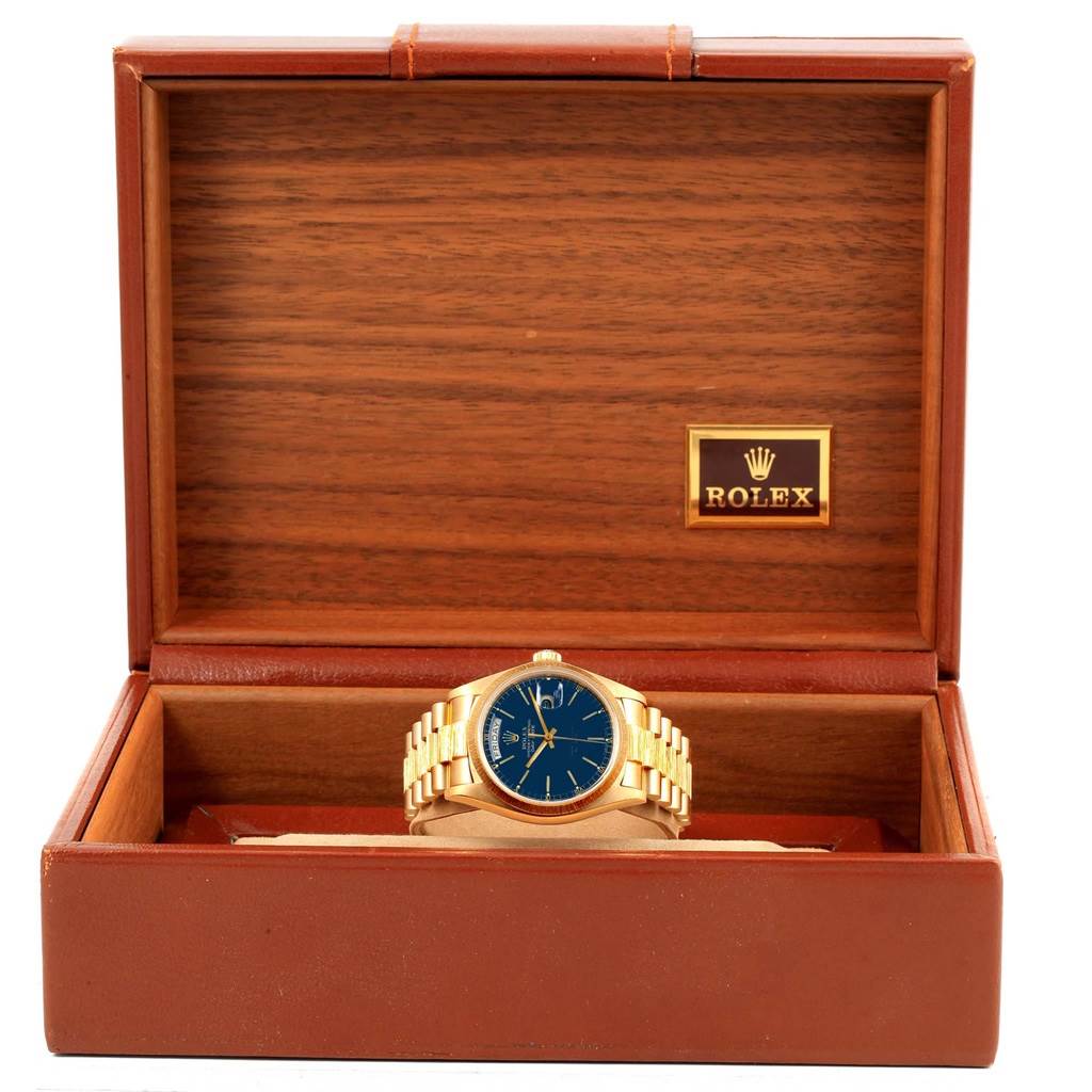 The Rolex President 18078 Men
s Yellow Gold Blue Dial 18078 Men
s Yellow Gold Blue Dial model watch is shown from the front inside an open brown wooden box.