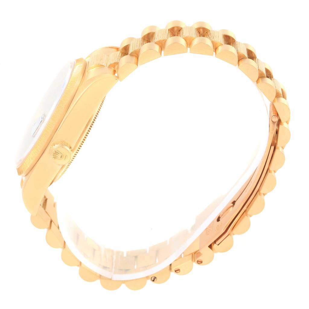 The image shows a side profile of the Rolex President 18078 Men
s Yellow Gold Blue Dial 18078 Men
s Yellow Gold Blue Dial model watch, highlighting its gold case, crown, and bracelet.