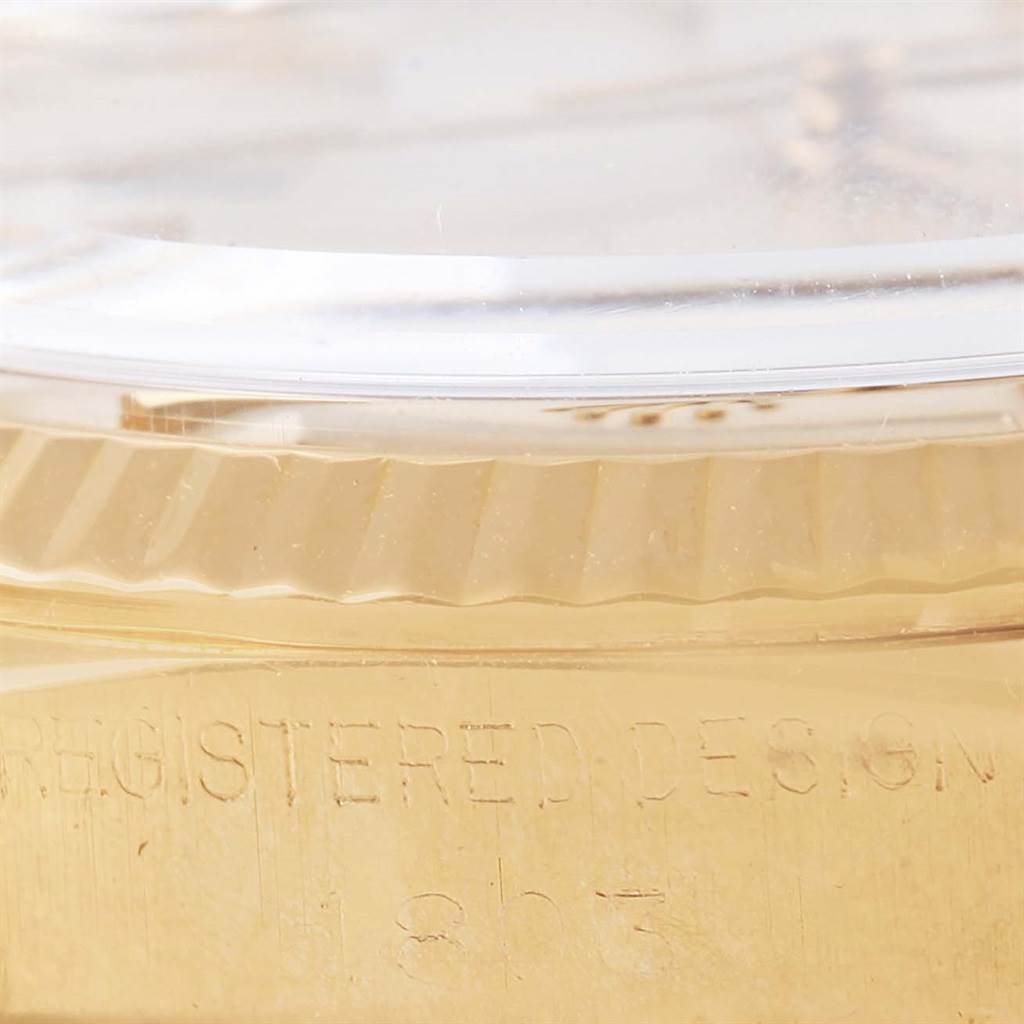 This close-up image of a Rolex President 1803 Men's Yellow Gold Silver Dial 1803 Men's Yellow Gold Silver Dial model watch shows a section of the gold bezel and part of the crystal.