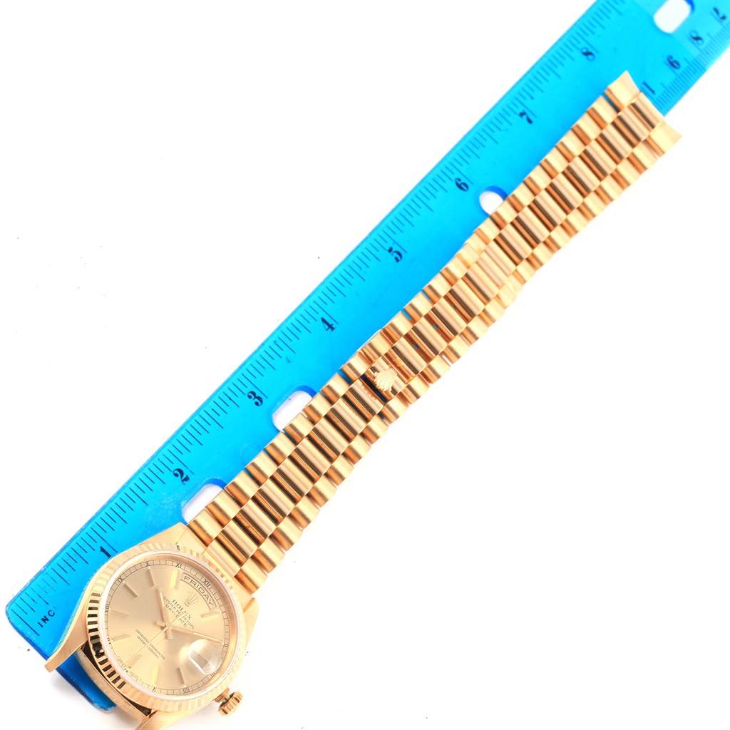 The Rolex President 18238 Men
s Yellow Gold Champagne Dial 18238 Men
s Yellow Gold Champagne Dial model watch is shown from an overhead angle, displaying the face and full length of the bracelet alongside a ruler.