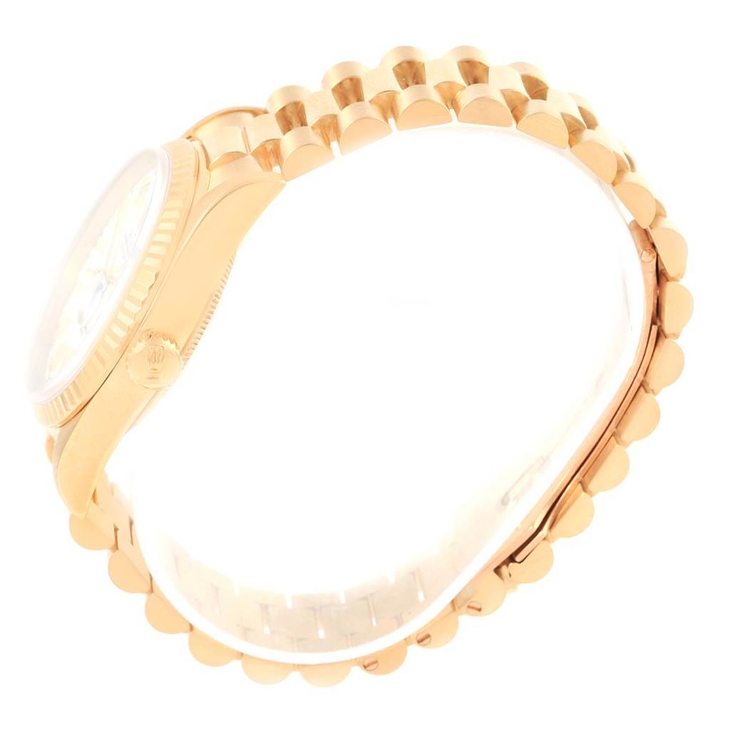 This side-angle view of a Rolex President 18238 Men
s Yellow Gold White Dial 18238 Men
s Yellow Gold White Dial model watch showcases the crown, case, and part of the bracelet.