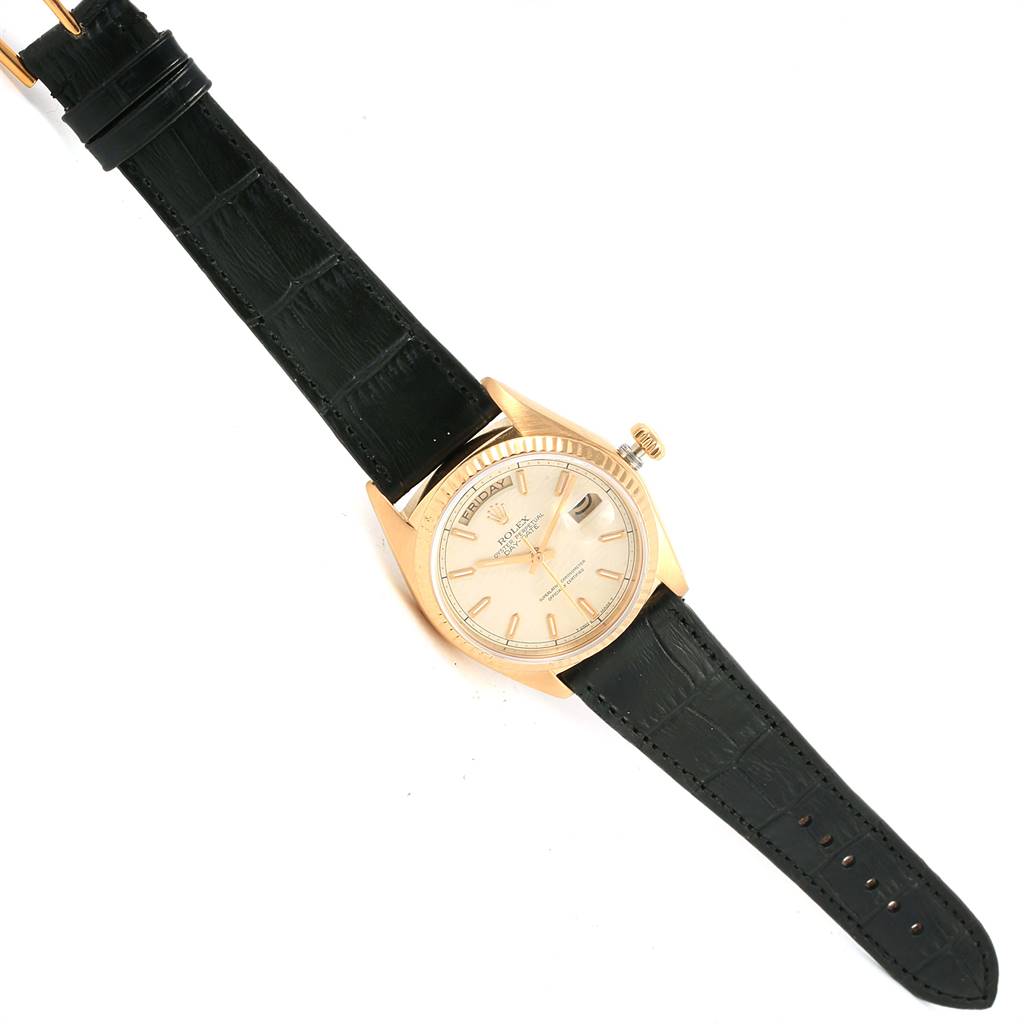 The image shows a Rolex President 18038 Men
s Yellow Gold Beige Dial 18038 Men
s Yellow Gold Beige Dial watch from a top-down angle, highlighting its face, case, crown, and leather strap.