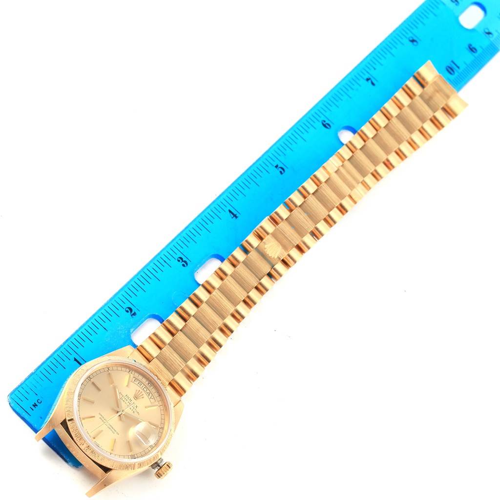 This image shows the Rolex President 18078 Men's Yellow Gold Champagne Dial 18078 Men's Yellow Gold Champagne Dial model watch laying flat with its face and bracelet visible, next to a blue ruler for measurement.