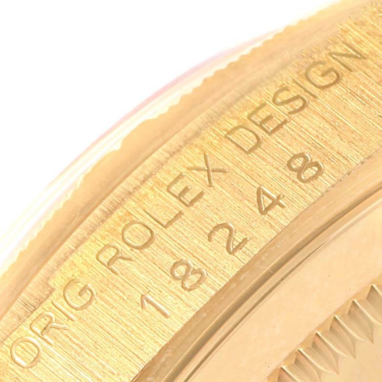 This close-up image shows the engraved bezel and part of the case of a Rolex President 18248 Men's Yellow Gold Champagne Dial 18248 Men's Yellow Gold Champagne Dial model watch.