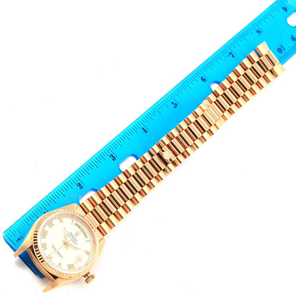 The image shows a Rolex President 18238 Men's Yellow Gold White Dial 18238 Men's Yellow Gold White Dial model watch laid flat beside a blue ruler, displaying its face and full bracelet.