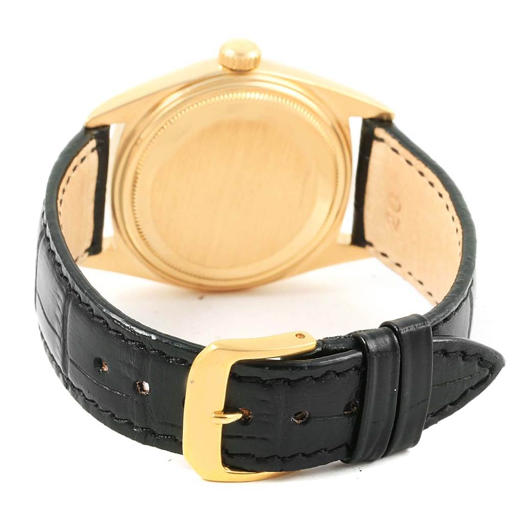 This image shows the back of a Rolex President 1803 Men's Yellow Gold Champagne Dial 1803 Men's Yellow Gold Champagne Dial model watch with a gold case and a black leather strap with a gold buckle.