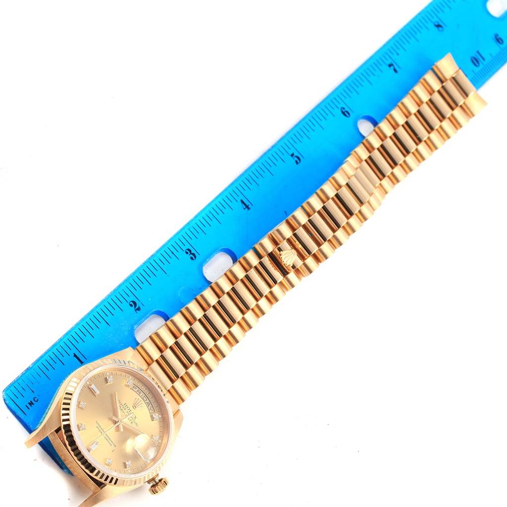 The image shows a top-down view of a Rolex President 17194 Men's Yellow Gold Champagne Dial 17194 Men's Yellow Gold Champagne Dial model watch alongside a blue ruler for measurement.