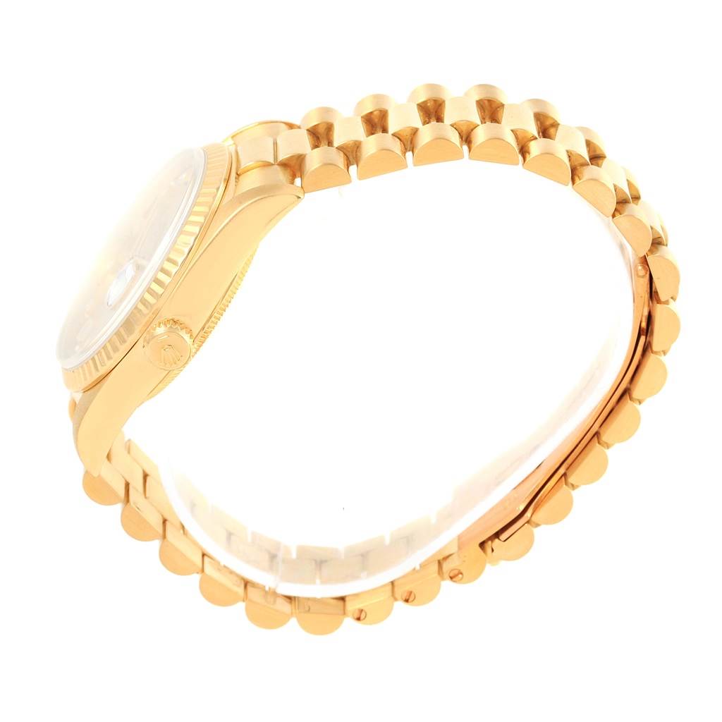 This image shows a side view of the Rolex President 18238 Men's Yellow Gold Champagne Dial 18238 Men's Yellow Gold Champagne Dial watch, displaying its gold bracelet, crown, and bezel.