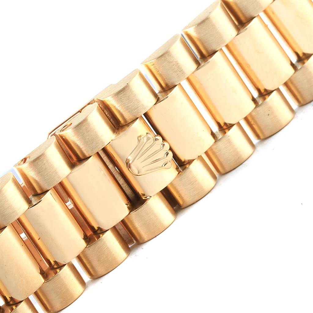 This image shows a close-up of the gold bracelet of a Rolex President 18238 Men's Yellow Gold Champagne Dial 18238 Men's Yellow Gold Champagne Dial model watch, highlighting the iconic crown logo.