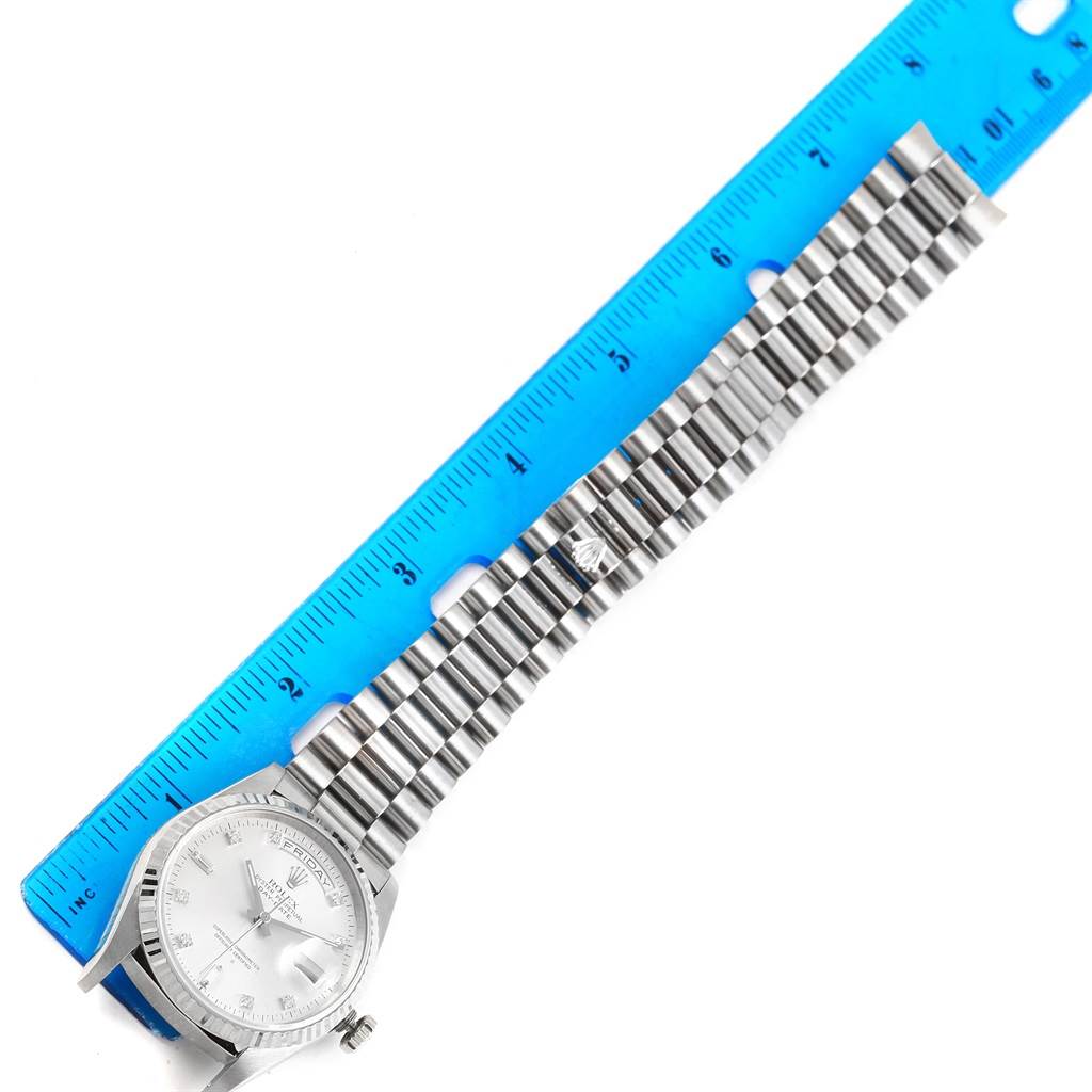 The Rolex President 18239 Men's White Gold Silver Dial 18239 Men's White Gold Silver Dial model watch is displayed horizontally with its face, bracelet, and part of a blue ruler for scale.