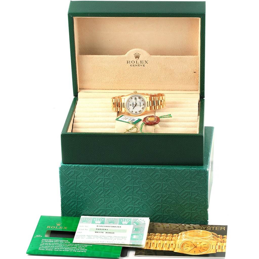 The image shows a Rolex President 18238 Men's Yellow Gold White Dial 18238 Men's Yellow Gold White Dial model watch in its open box with accompanying certification and booklets arranged in front.