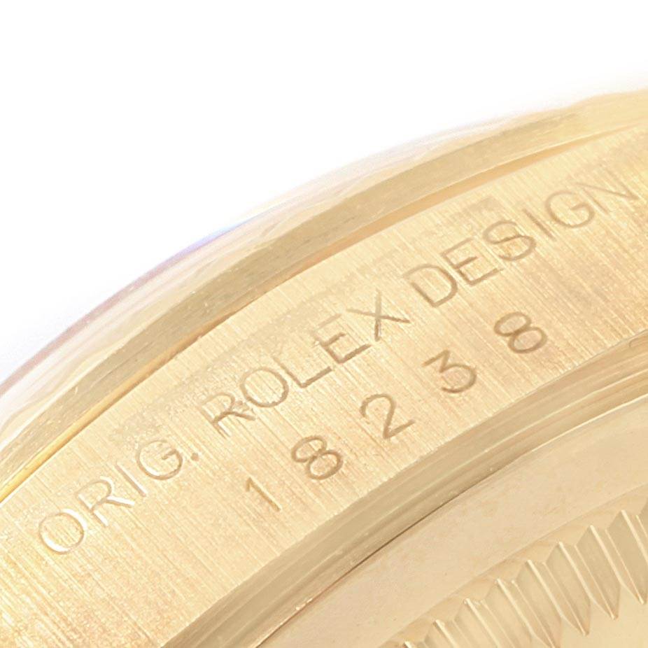 This close-up image of a Rolex President 18238 Men's Yellow Gold White Dial 18238 Men's Yellow Gold White Dial model shows the engraved lettering and serial number on the case.
