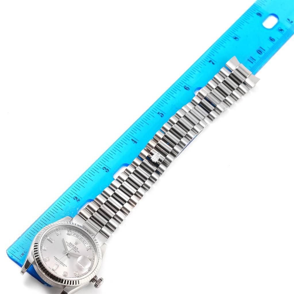 The image shows a Rolex President 118239 Men's White Gold Silver Dial 118239 Men's White Gold Silver Dial model watch, displayed alongside a blue ruler, highlighting its face and bracelet.