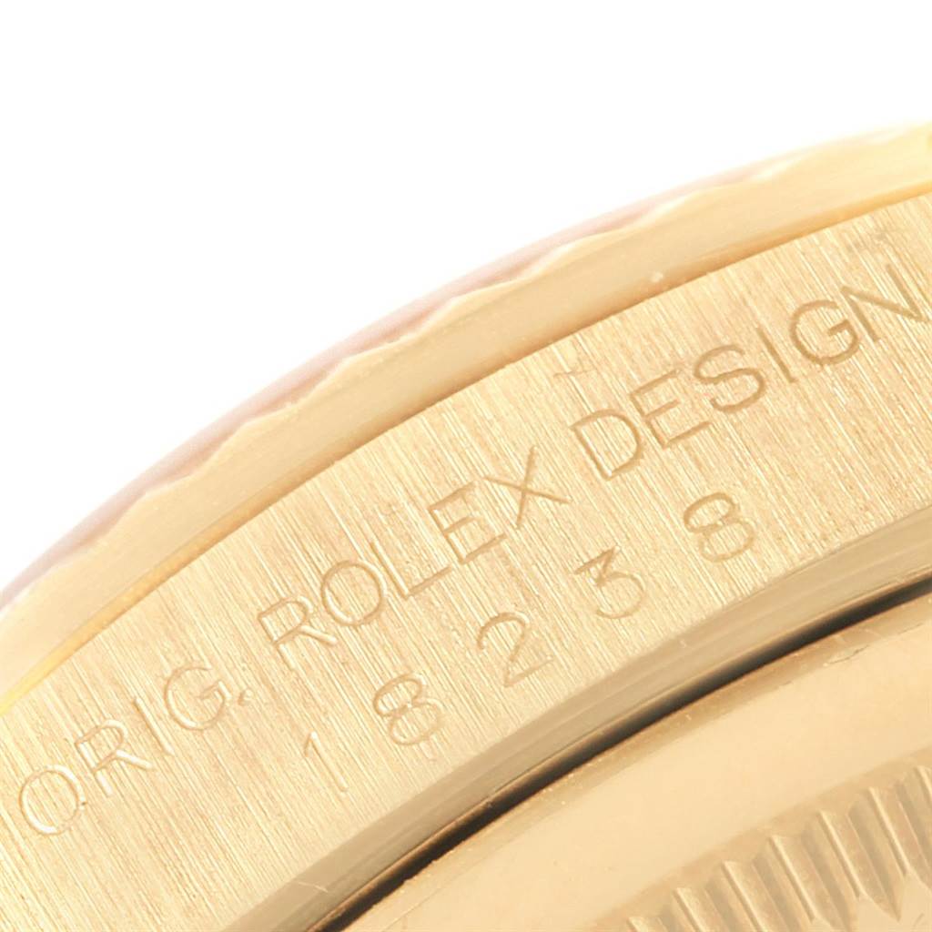 Close-up view of the bezel and engraved lettering on a Rolex President 18238 Men's Yellow Gold Champagne Dial 18238 Men's Yellow Gold Champagne Dial model watch.