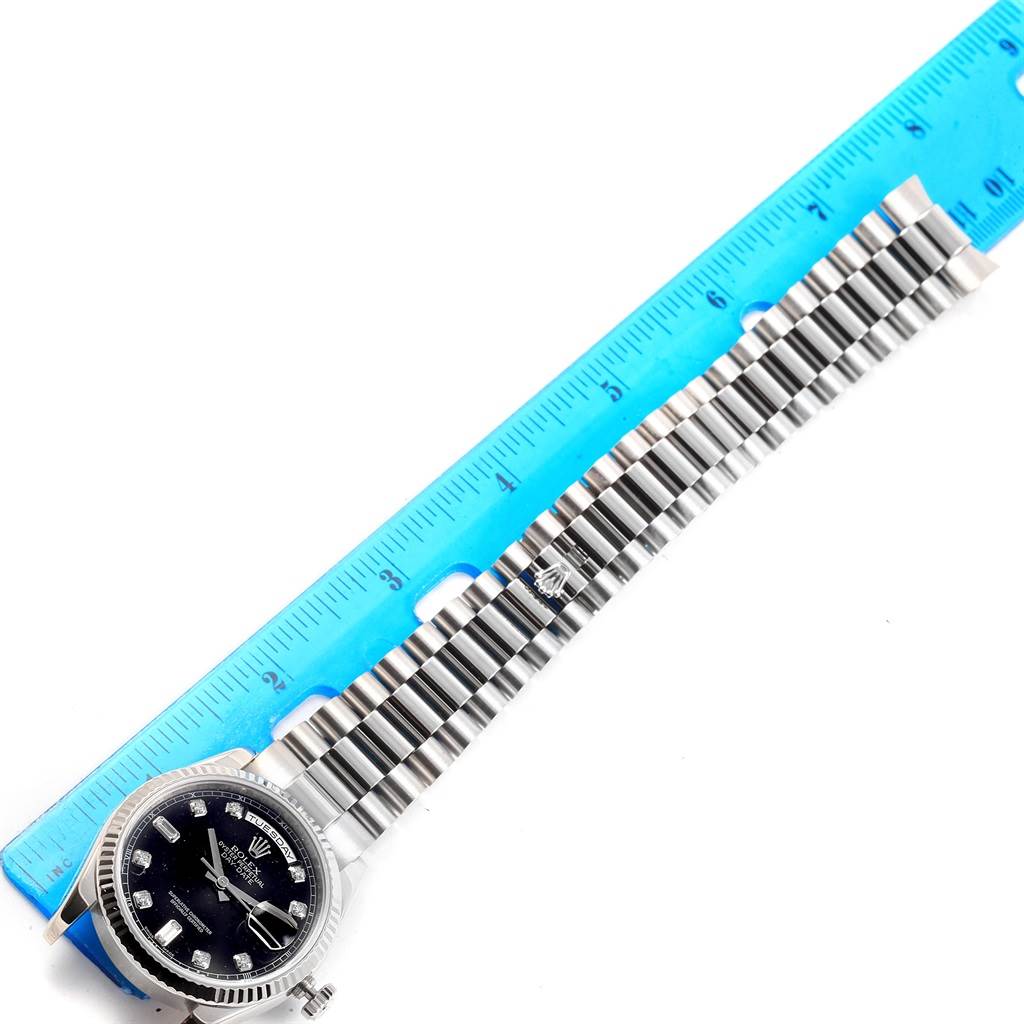 This image shows the Rolex President 118239 Men's White Gold Black Dial 118239 Men's White Gold Black Dial model watch from a top-down view, highlighting the face, bezel, and bracelet next to a ruler.