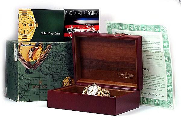 The image shows the Rolex President 18038 Men's Yellow Gold Silver Dial 18038 Men's Yellow Gold Silver Dial watch inside an open wooden box, with associated booklets and documents displayed around it.