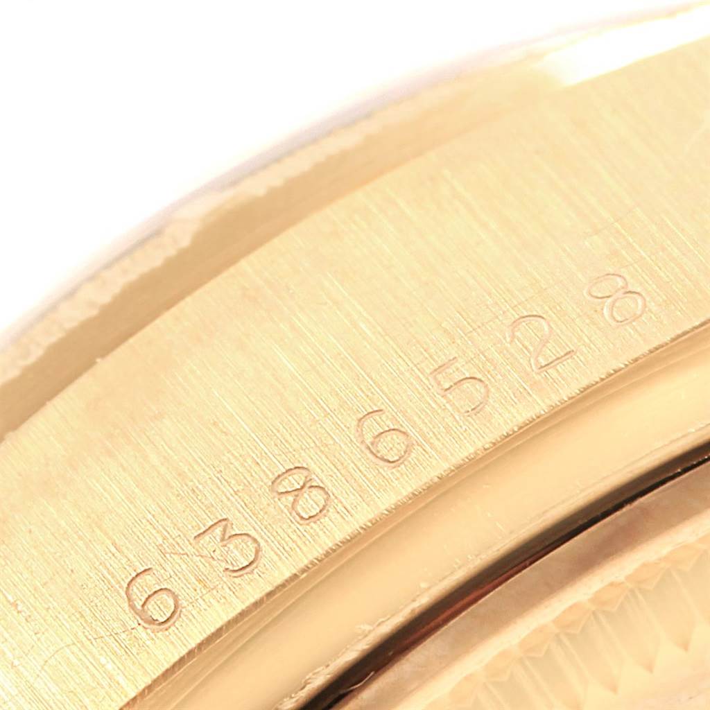 This image shows a close-up of the Rolex President 18078 Men
s Yellow Gold Champagne Dial 18078 Men
s Yellow Gold Champagne Dial model
s bezel with a serial number engraved.