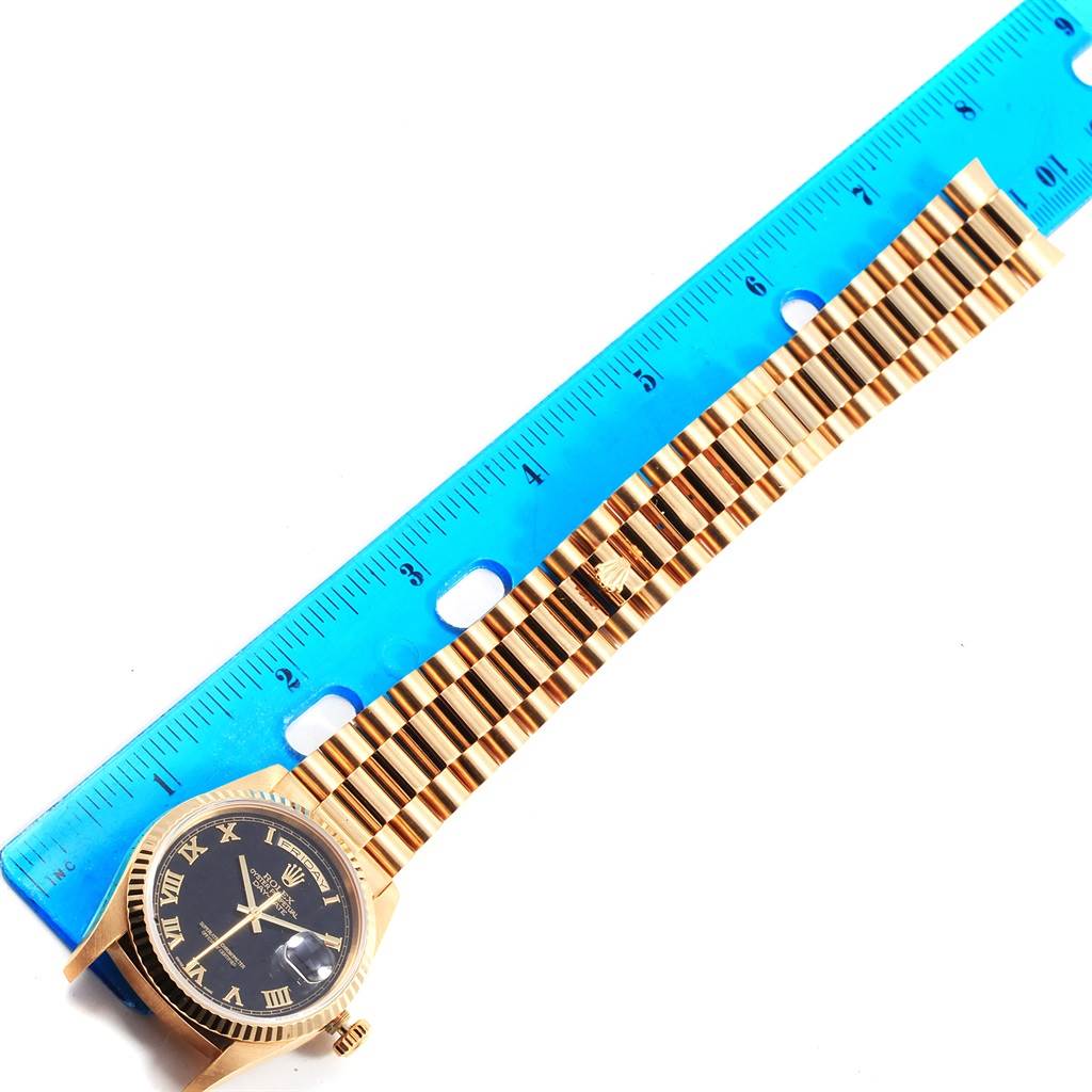 The image shows the Rolex President 18238 Men's Yellow Gold Black Dial 18238 Men's Yellow Gold Black Dial model watch horizontally aligned with a blue ruler placed beside it for measurement.